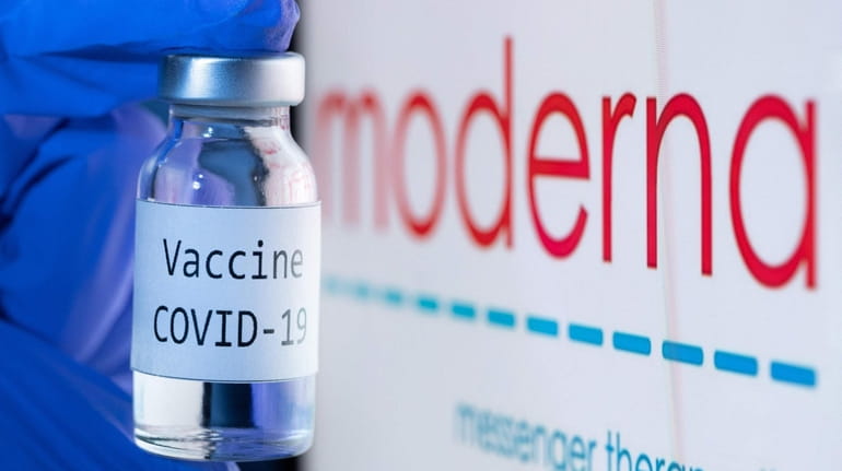 A bottle reading "Vaccine Covid-19" next to the Moderna biotech...