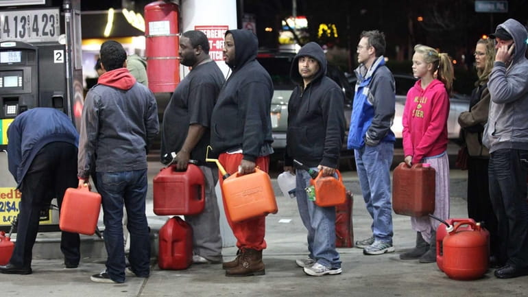 Three days after superstorm Sandy, people wait in line with...