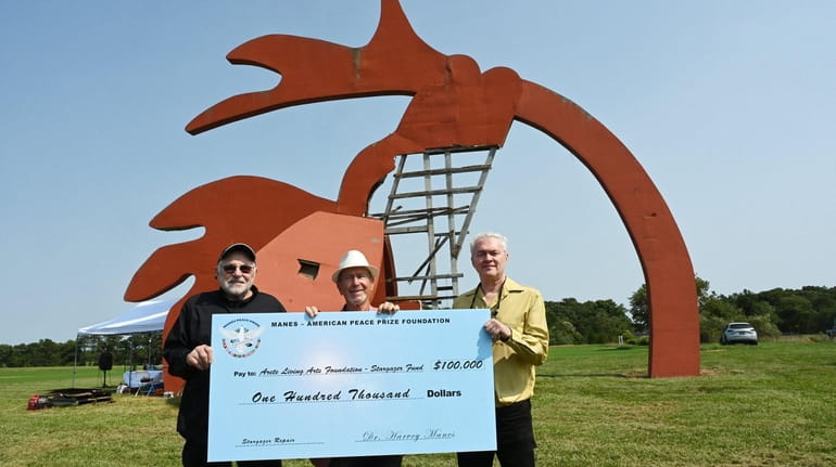 Harvey Manes, center, donated $100,000 to restore the Stargazer sculpture in Manorville....