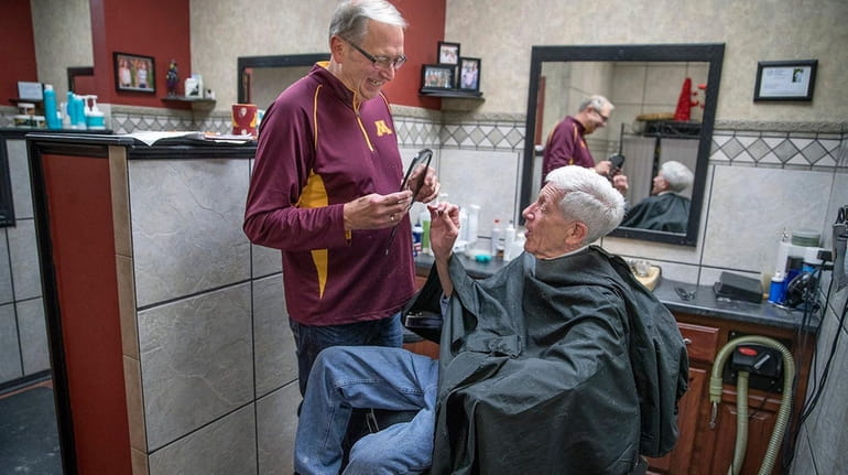 Barber John Vreeman gives longtime customer Bill Rosenblom a peek...