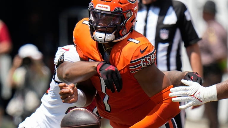 Chicago Bears quarterback Justin Fields (1) fumbles the ball as...