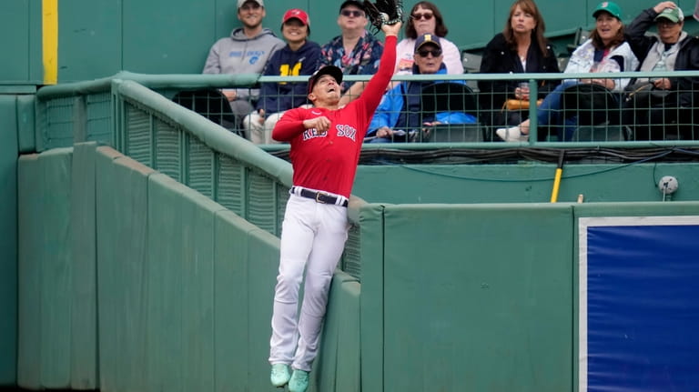 Boston Red Sox center fielder Enrique Hernandez leaps and makes...