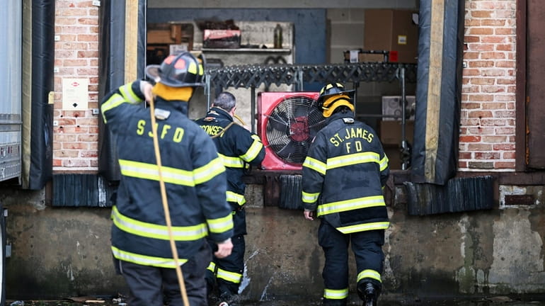 Firefighters vent smoke after a fire broke out Friday morning...