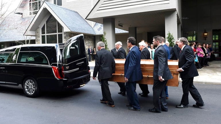 Pallbearers carry the body of Rev. Billy Graham into a...
