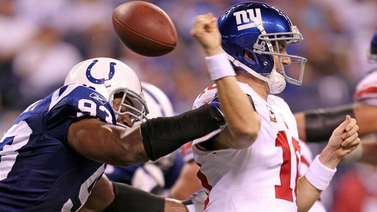 Indianapolis' Dwight Freeney hits Giants quarterback Eli Manning causing a...