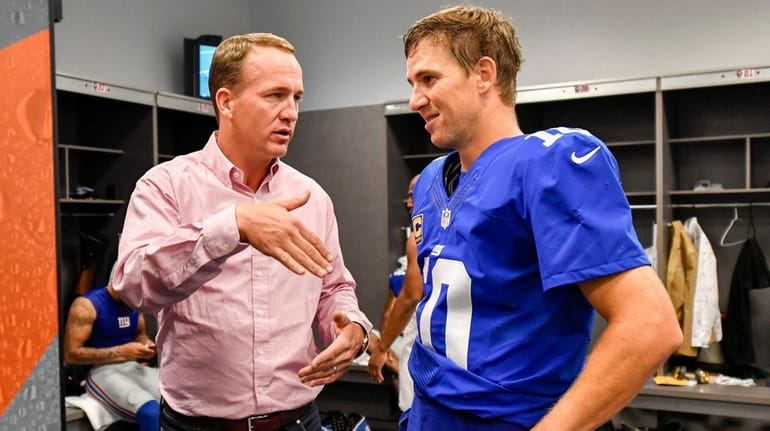 New York Giants quarterback Eli Manning talks with his brother...