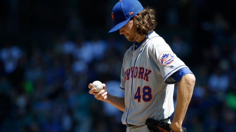 Mets pitcher Jacob deGrom looks at the ball after he...