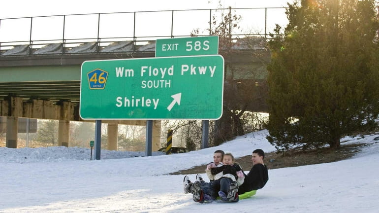 Sledders ride a hill at Sunrise Highway Exit 58 in...