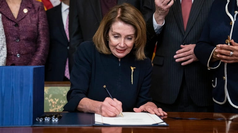 Speaker of the U.S. House of Representatives Nancy Pelosi signs...