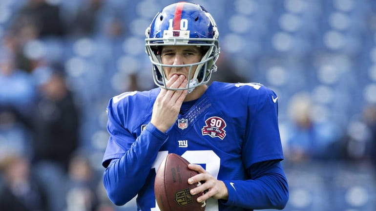 Eli Manning of the New York Giants warming up before...