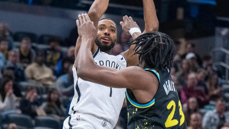 Nets forward Mikal Bridges shoots while being defended by Pacers...