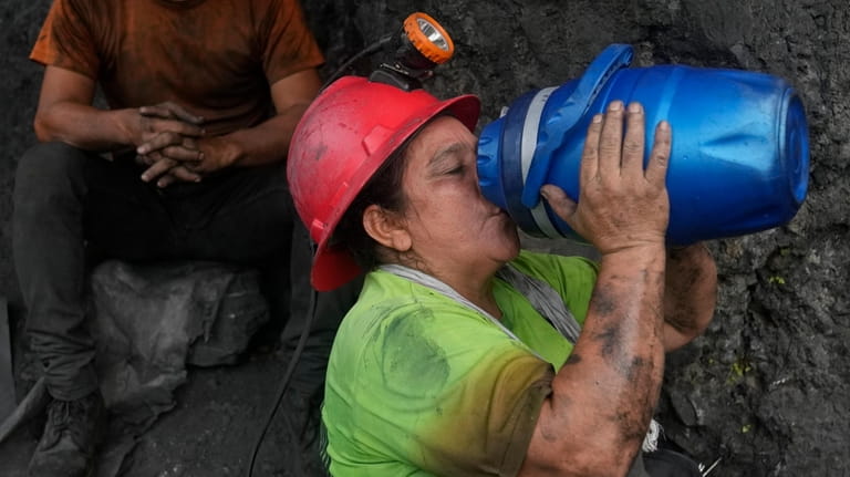 Emerald miner Yaneth Forero, 52, hydrates during a break outside...