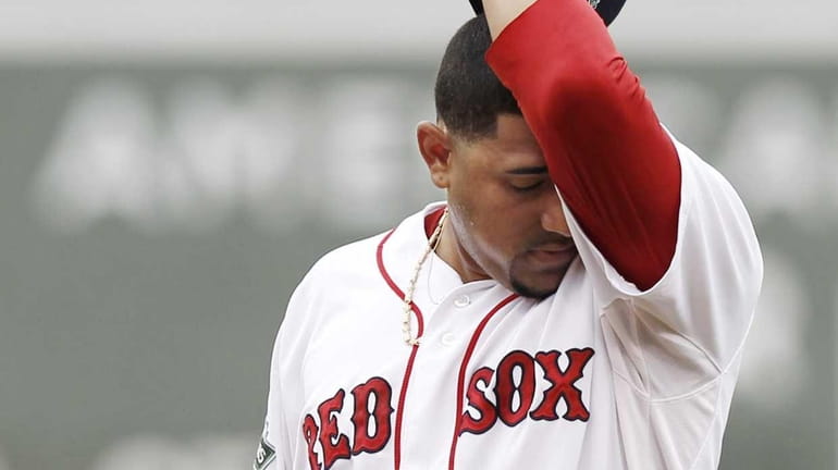 Franklin Morales of the Boston Red Sox wipes his face...