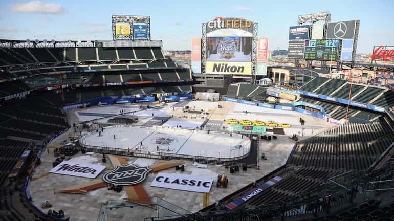Workers prepare the rink before the 2018 Winter Classic at...