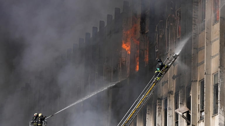Firefighters tackle a blaze at the site of a Russian...