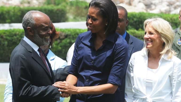 Michelle Obama, center, greets Haitian Prime Minister Rene Preval during...