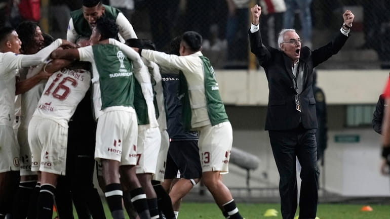 Coach Jorge Fossati of Peru's Universitario, right, celebrates his side's...