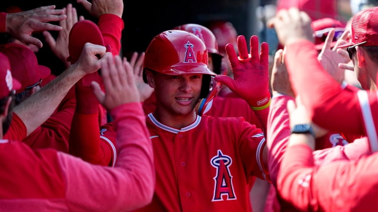 Los Angeles Angels' Logan O'Hoppe high-fives teammates after scoring in...