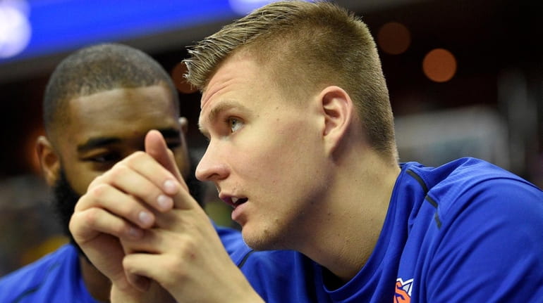 Knicks forward Kristaps Porzingis watches from the bench during the...