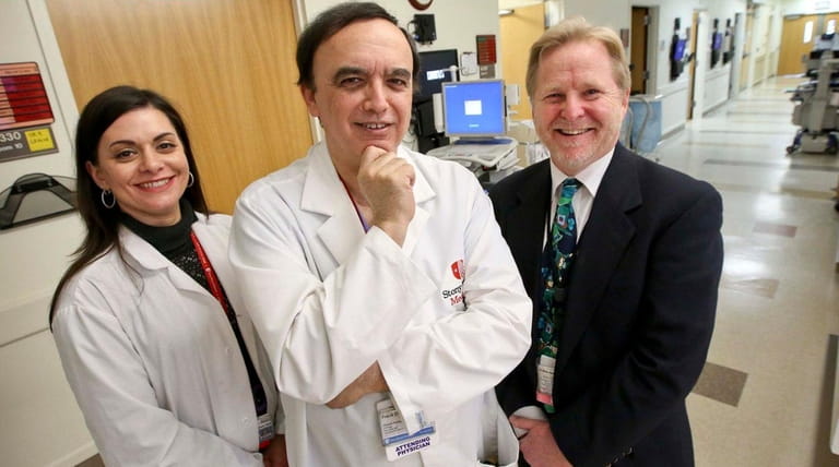 Transplant surgeon Dr. Frank Darras, center, is flanked by transplant...