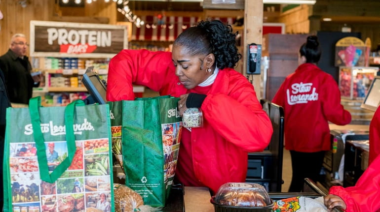Cashier Lorna Horton packs a customer's reusable bags at Stew...
