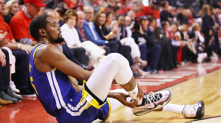 Kevin Durant of the Warriors reacts after sustaining an Achilles...