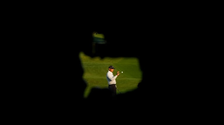 Tiger Woods warms up on the driving range during a...