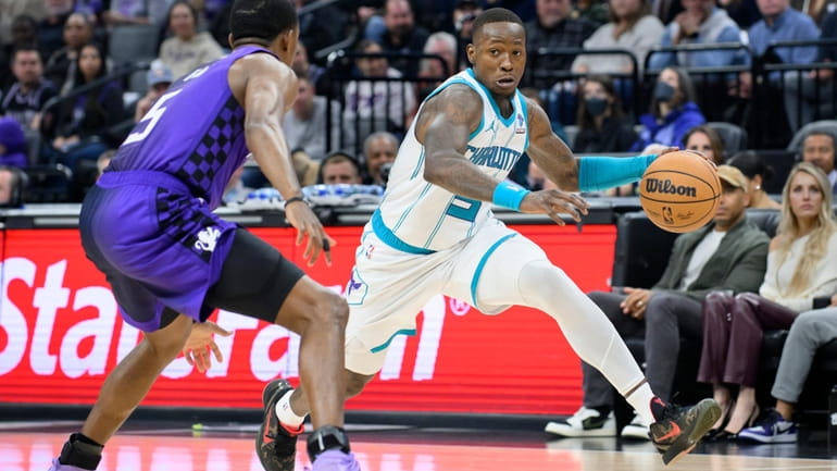 Charlotte Hornets guard Terry Rozier, right, dribbles past Sacramento Kings...