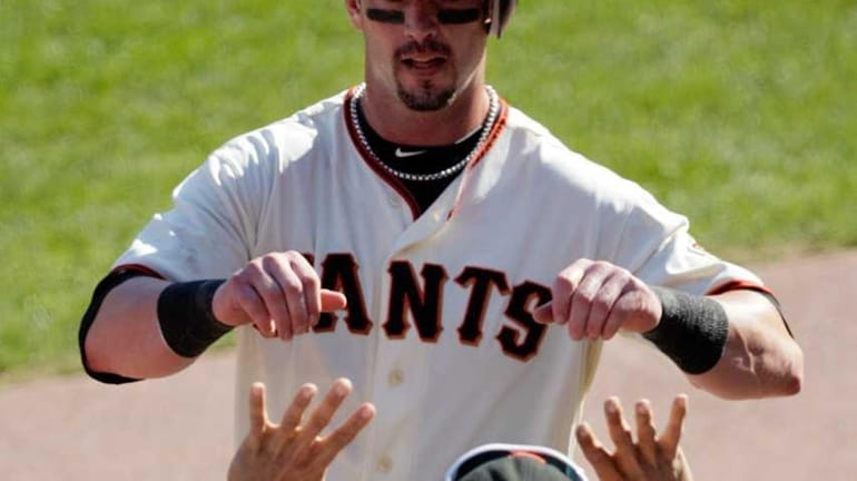 San Francisco Giants' Aaron Rowand is congratulated by Andres Torres...
