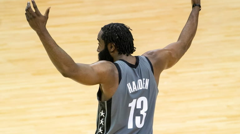 Nets guard James Harden celebrates after an assist during the first...