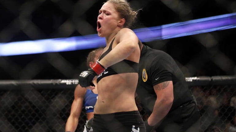 Ronda Rousey celebrates defeating Liz Carmouche after their UFC 157...