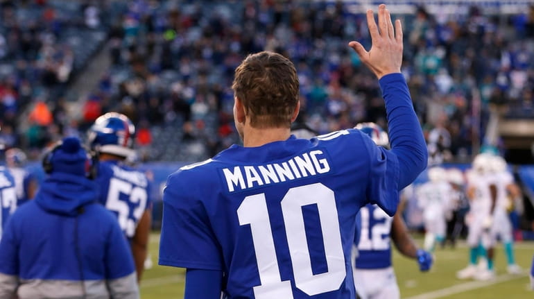 Eli Manning of the Giants waves to the fans from...