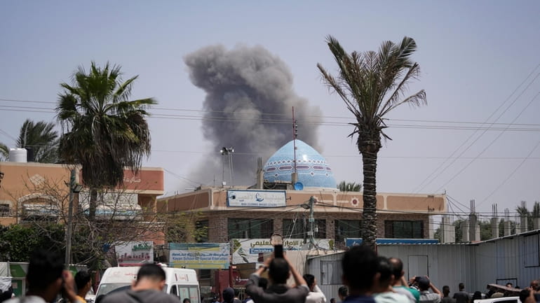 Smoke rises following an Israeli airstrike in Deir al Balah,...