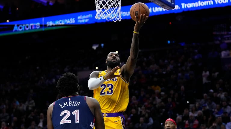 Los Angeles Lakers' LeBron James, center, goes up for a...