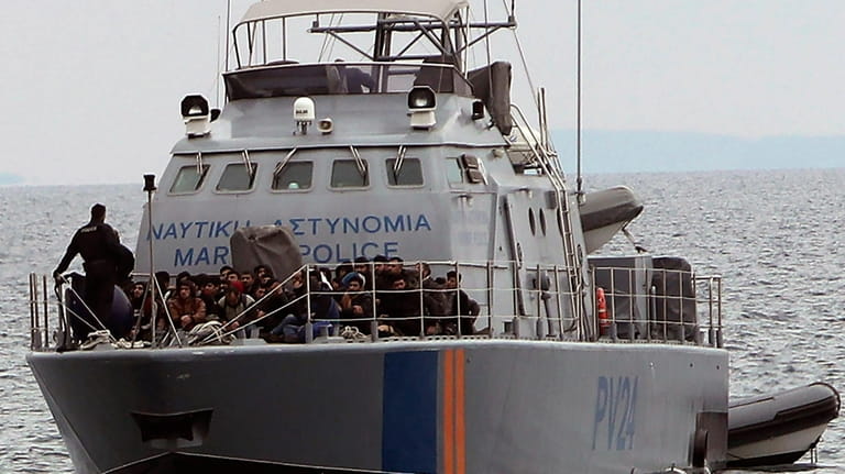 Migrants aboard a Cyprus marine police patrol boat as they're...