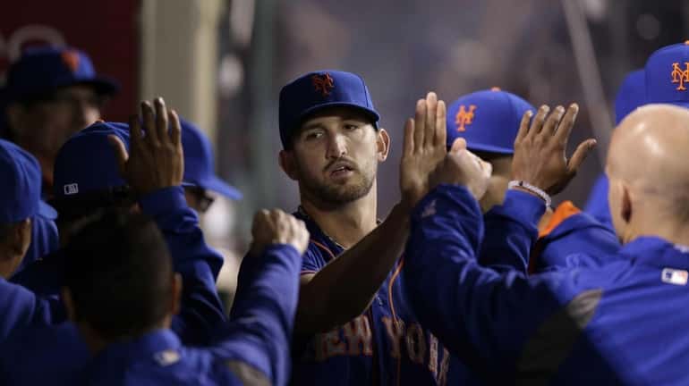 Mets starting pitcher Jonathon Niese, center, is greeted by teammates...