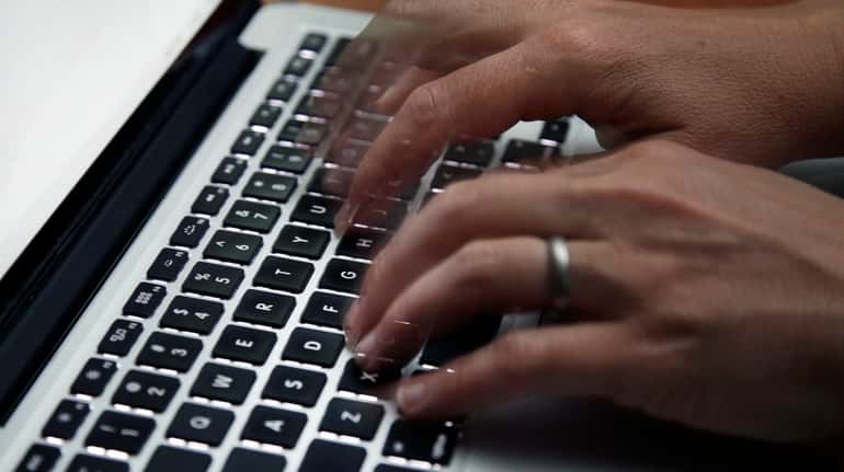 A person works on a laptop in North Andover, Mass....