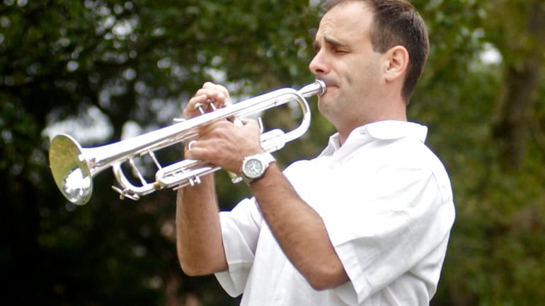 Brian Stabile, band director at Lawrence High School, plays "Taps"...