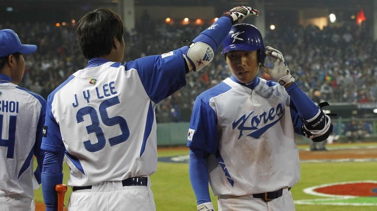 South Korea outfielder Lee Jin-Young, left, congratulates infielder Jung-Ho Kang...
