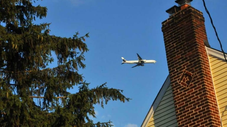 A plane flies over a Stewart Manor home. (July 14,...