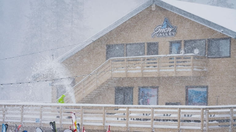 Snow falls on the Big Mountain Resort property during a...
