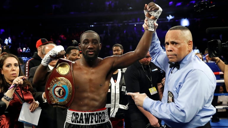 Terence Crawford has his hand raised in victory after defeating...