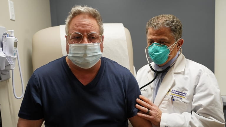 Dr. Anthony P. Ardito, right, checks patient Gary Valentine at...