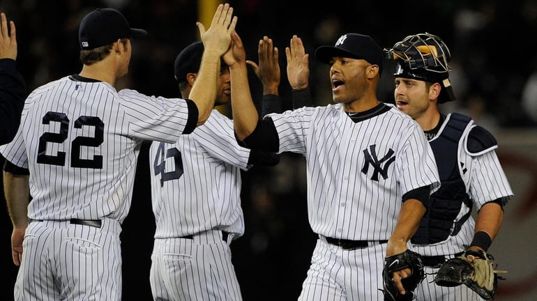 Yankees pitcher Mariano Rivera and teammates celebrate a 4-3 win...