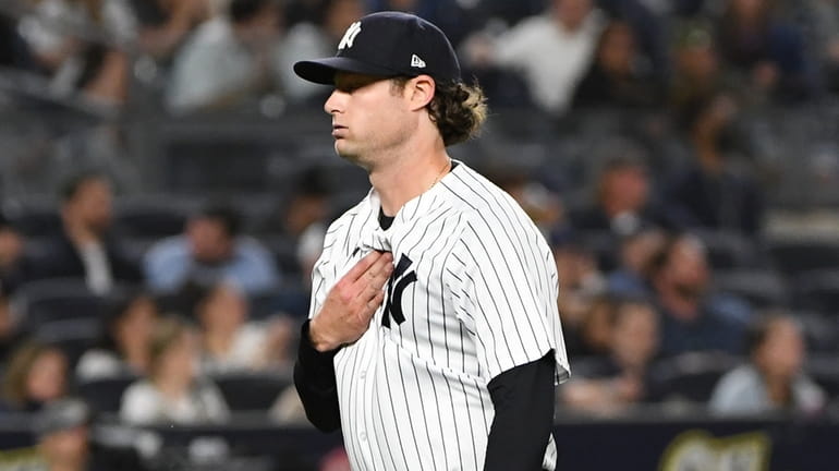 Yankees starting pitcher Gerrit Cole reacts as he walks to...