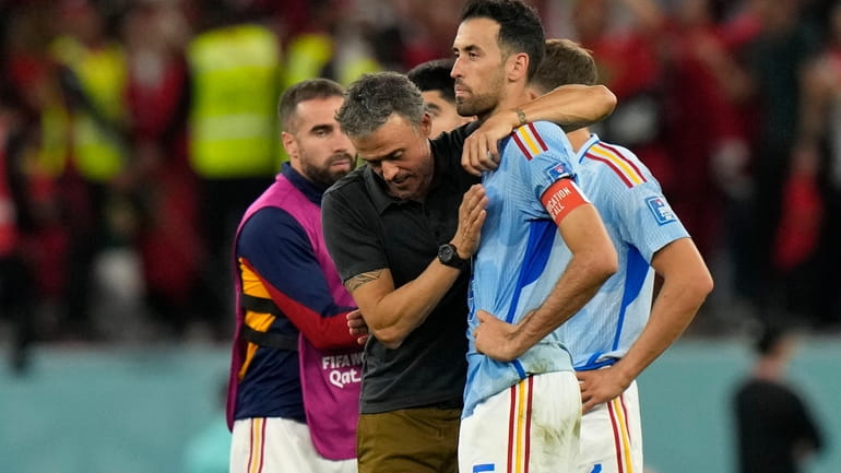 Spain's head coach Luis Enrique, left, embraces Sergio Busquets after...