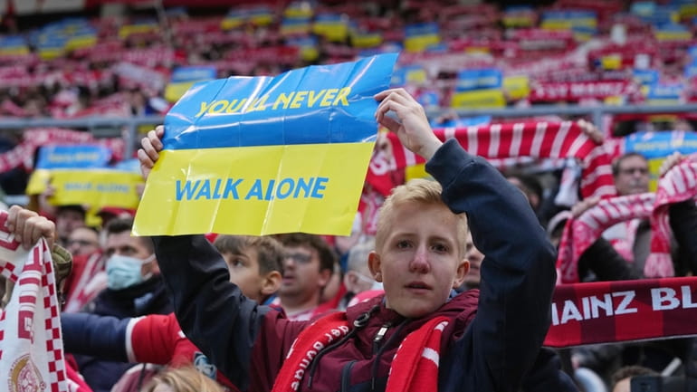 Mainz supporters hold up Ukraine flag messages showing their support...