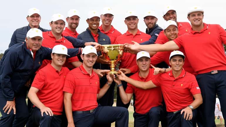 FILE - The U.S. team hold their trophy after they...
