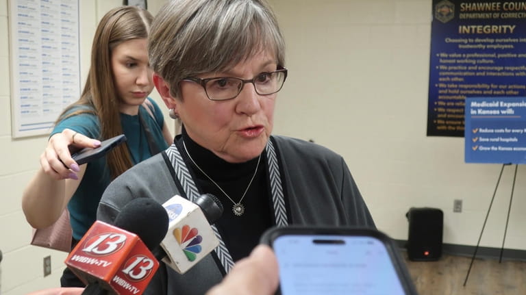 Kansas Gov. Laura Kelly answers questions from reporters following a...