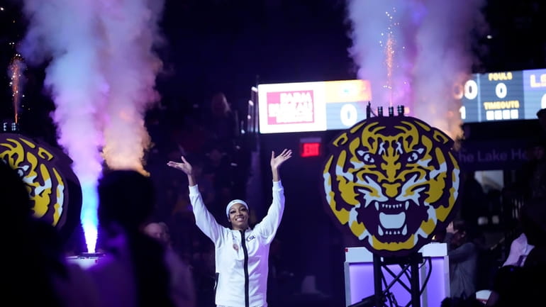 LSU forward Angel Reese waves to the crowd as she...
